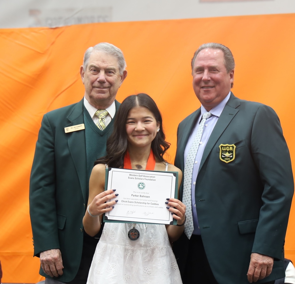 Two representatives with students and award of Chick Evans scholarship for caddies