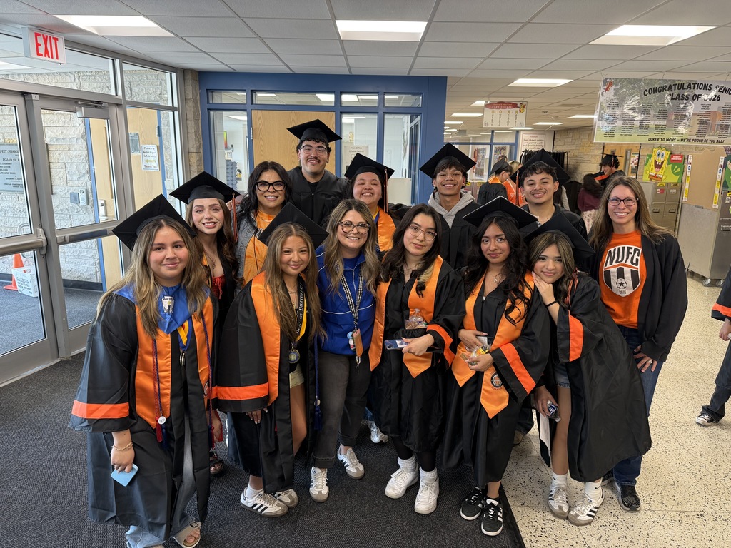 Students in caps and gowns with a few staff members