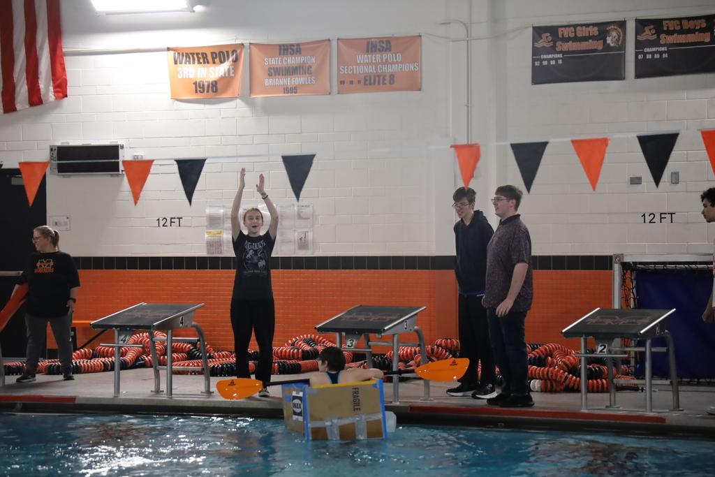 Students cheering while one student in box with oar is at the end of the pool