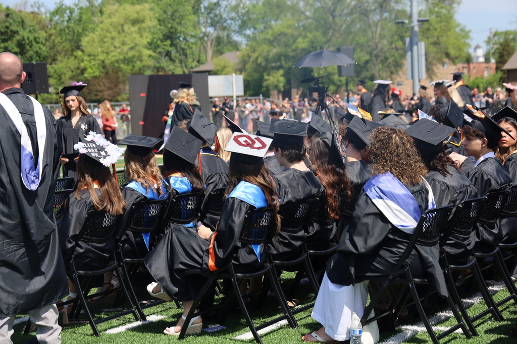 Students sitting at graduation. back of grad caps