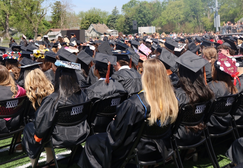 Students sitting at graduation. back of grad caps