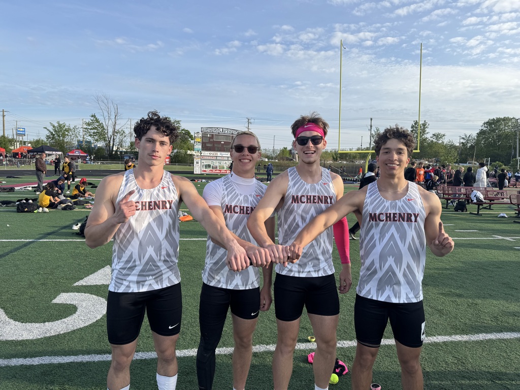 Jayden Linderman, James butler, Oliver Sznyterman, Jonah Miller putting their hands together and posing on field