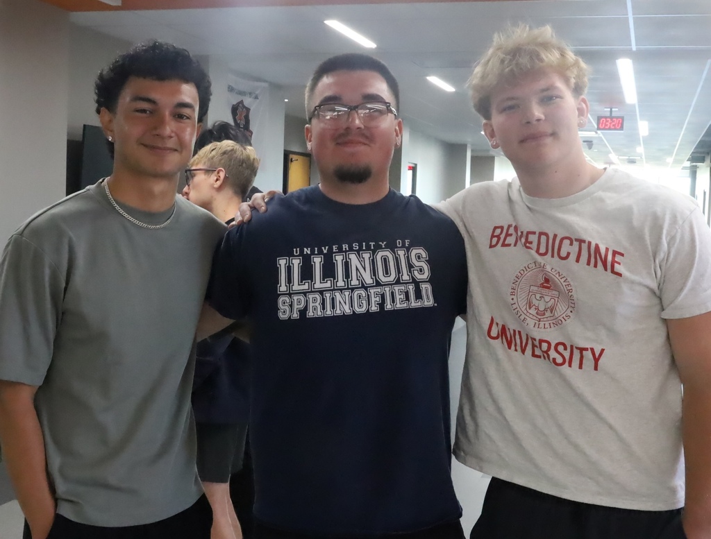 Three students posing with arms around each other