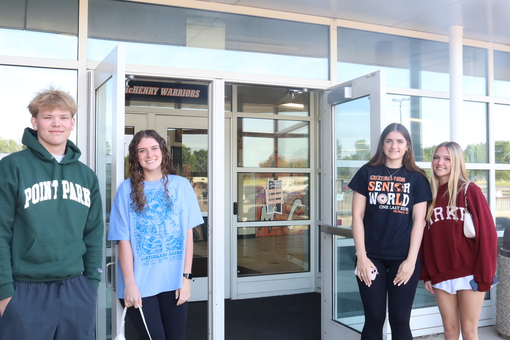Four students standing at the entryway of the school