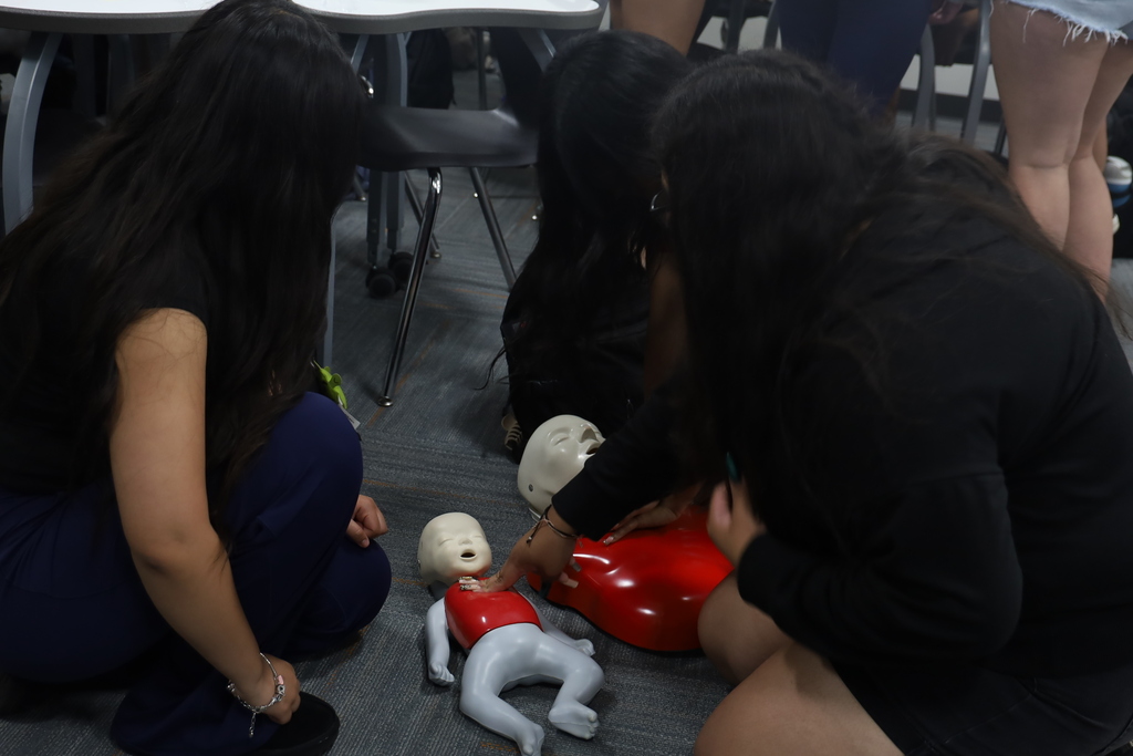 Students practicing CPR on baby CPR mannequin and adult mannequin 