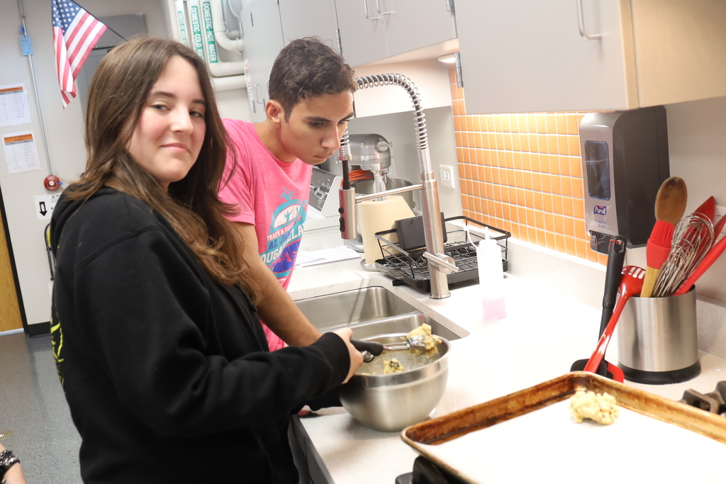 Two students scooping cookie dough