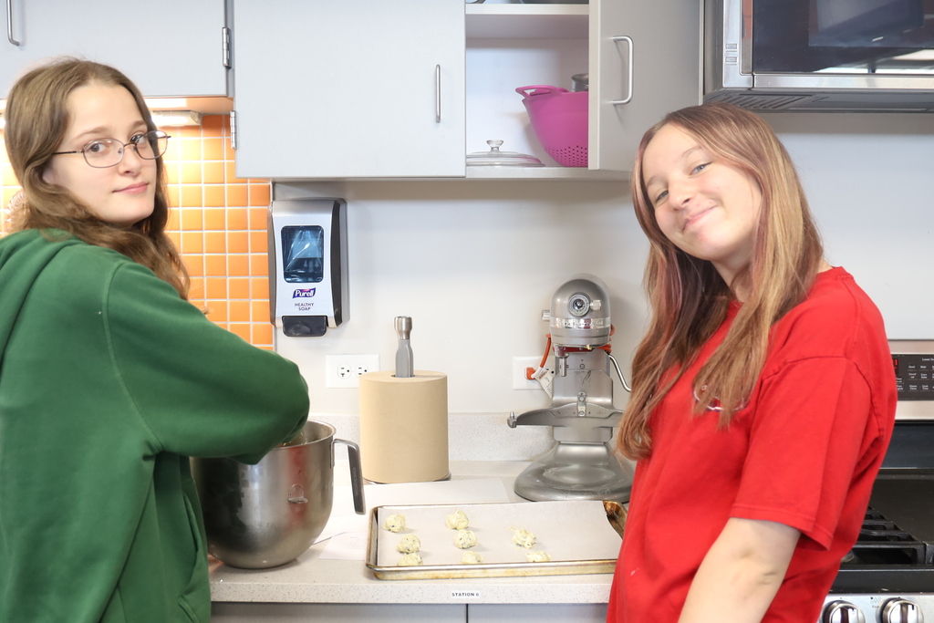 Two students scooping cookie dough