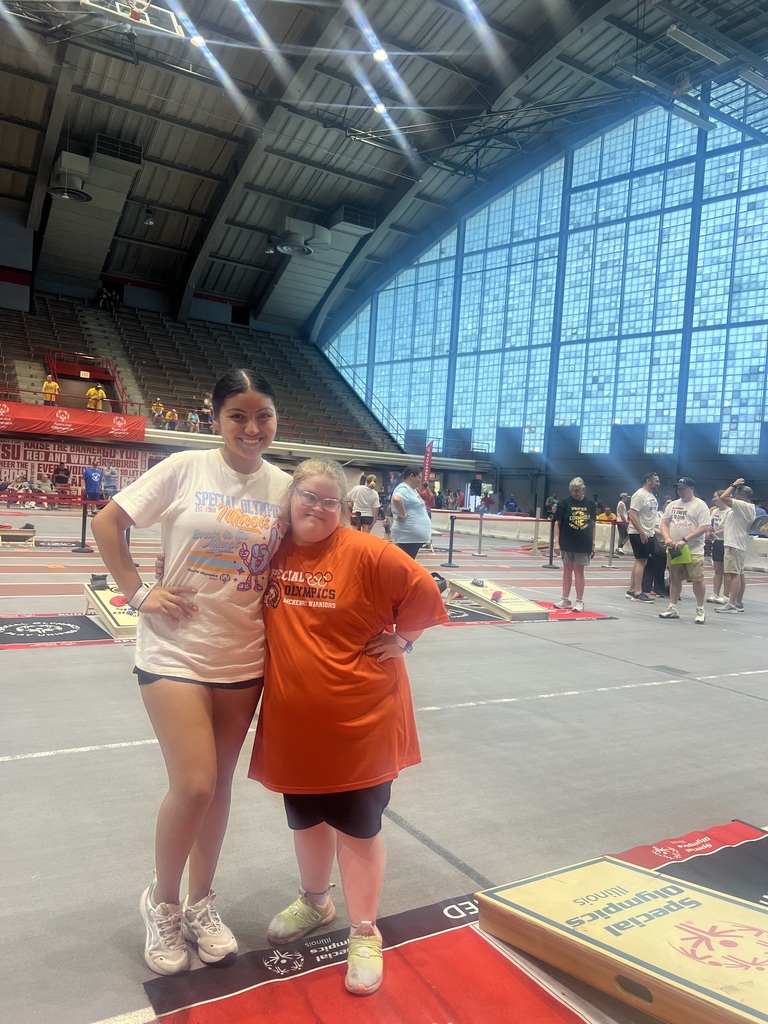 Ellie posing with another student by cornhole