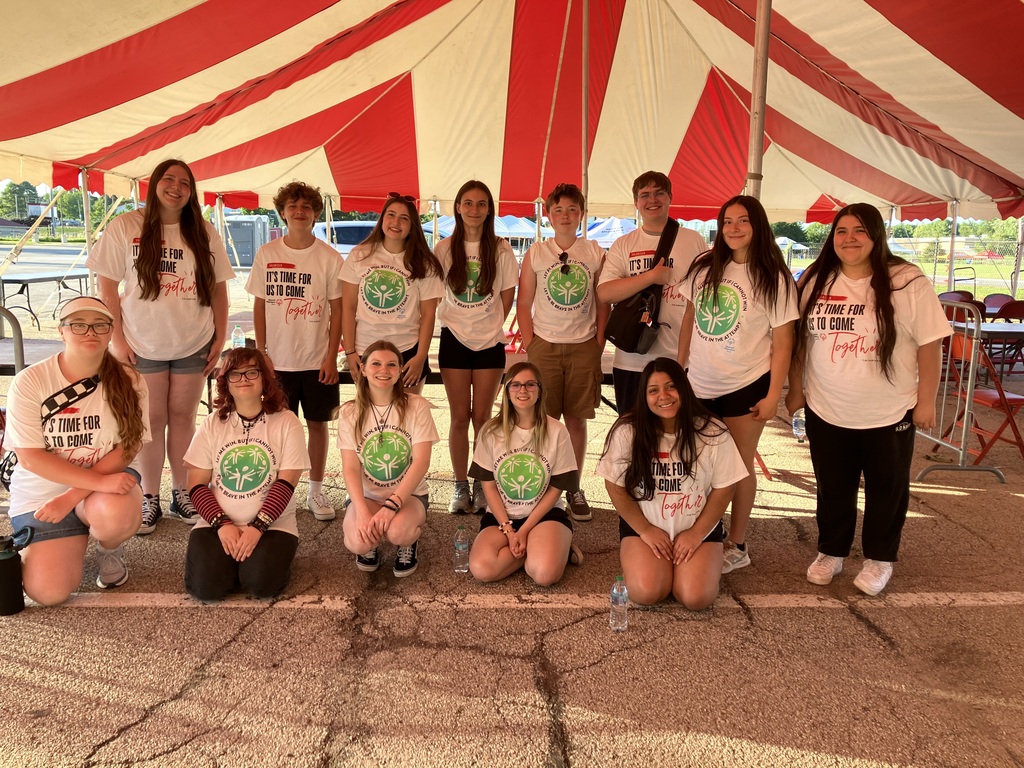 Thirteen students under a tent