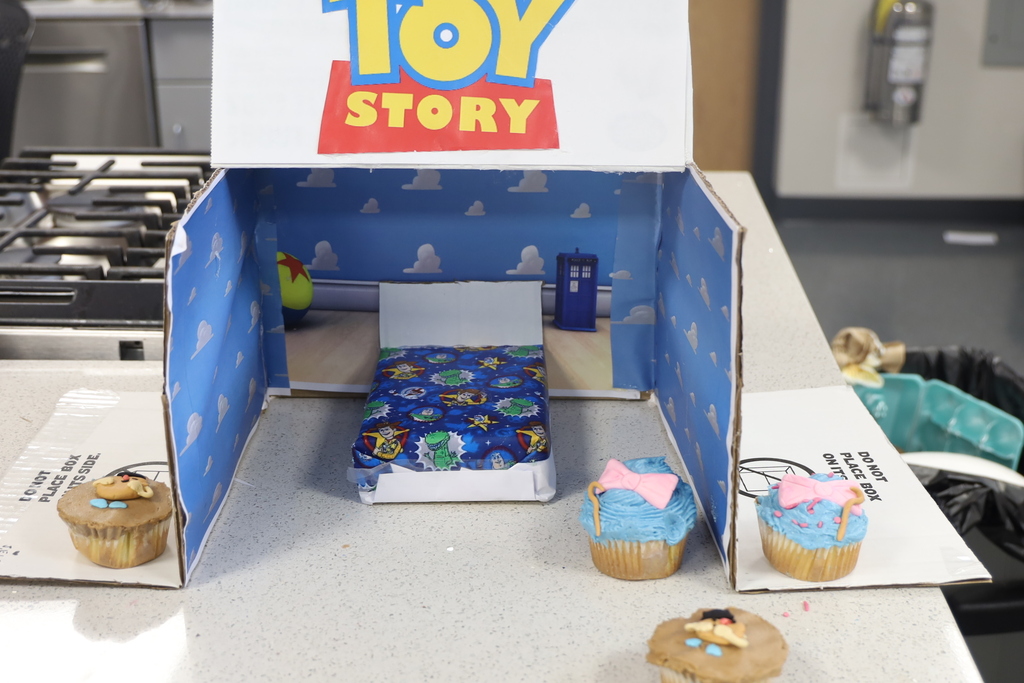 Toy story room made of cardboard with Toy Story themed cupcakes around it 