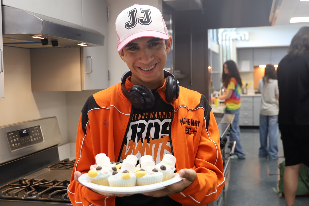Student holding decorated cupcakes