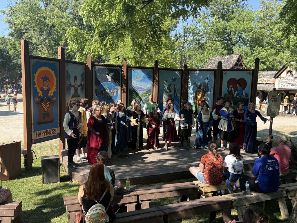 Choir students in renaissance costumes singing at the Ren Fair