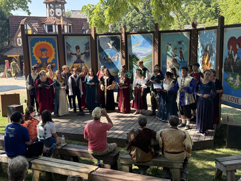 Choir students in renaissance costumes singing at the Ren Fair