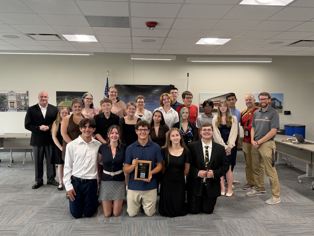 Group of students  with advisor, activities director, principal and superintendent holding their award