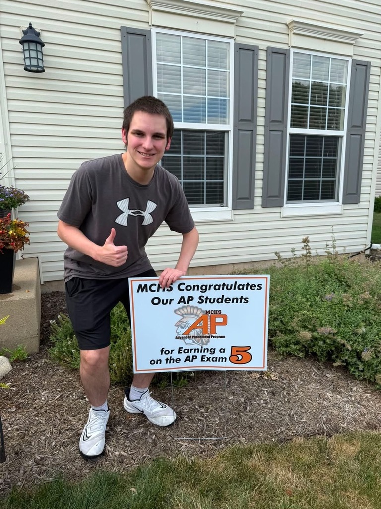 Student in yard with AP sign