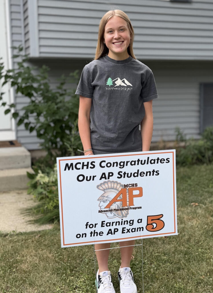 Student in yard with AP sign