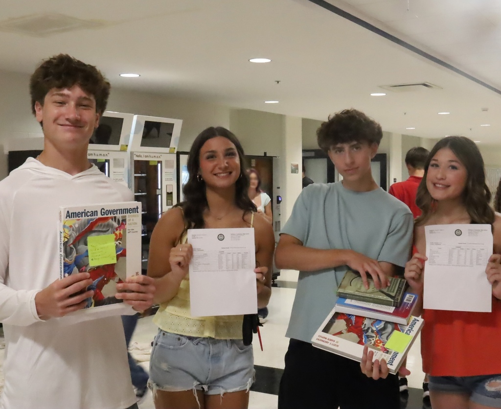 Students posing with their books and scheules