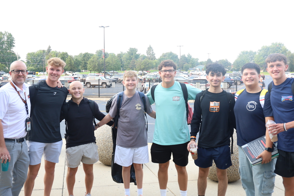 Seven students posing outside with Mr. Eiserman