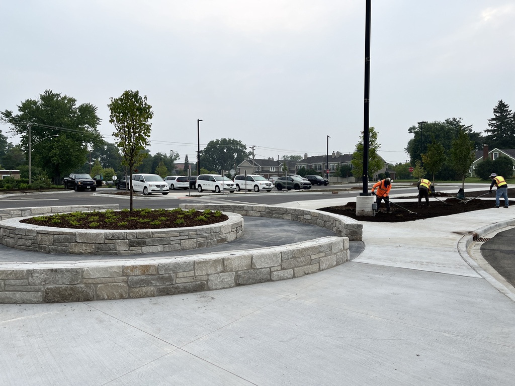 Workers installing more landscaping at the newly designed parking area behind Freshman Campus