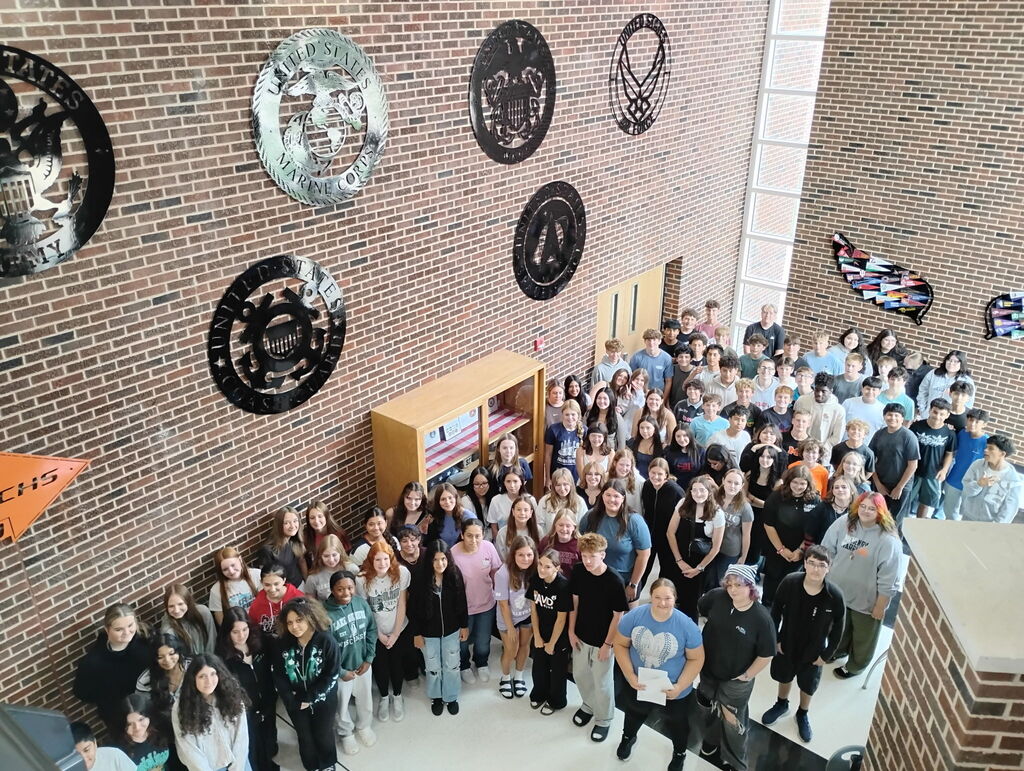 Overhead shot of a large group of Freshman students smiling at the camera
