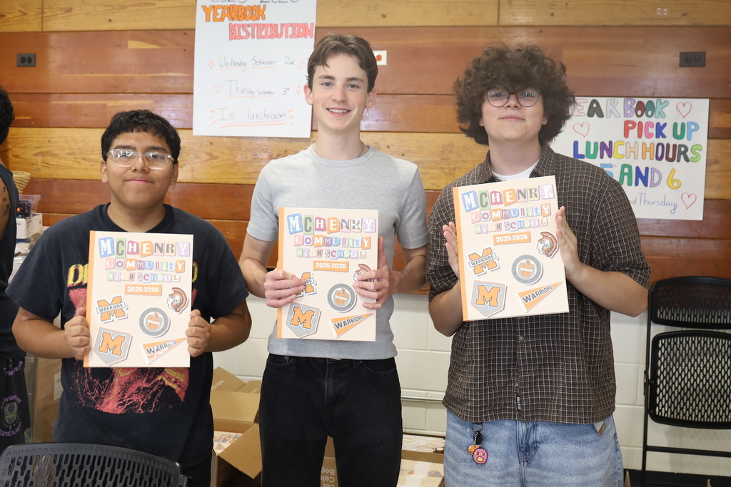 Three students holding 2025-2026 Yearbooks