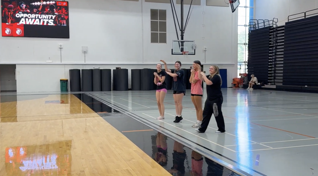 Cheerleaders providing pep for Special Olympics practice