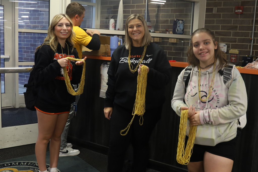 Students and teacher holding gold beads
