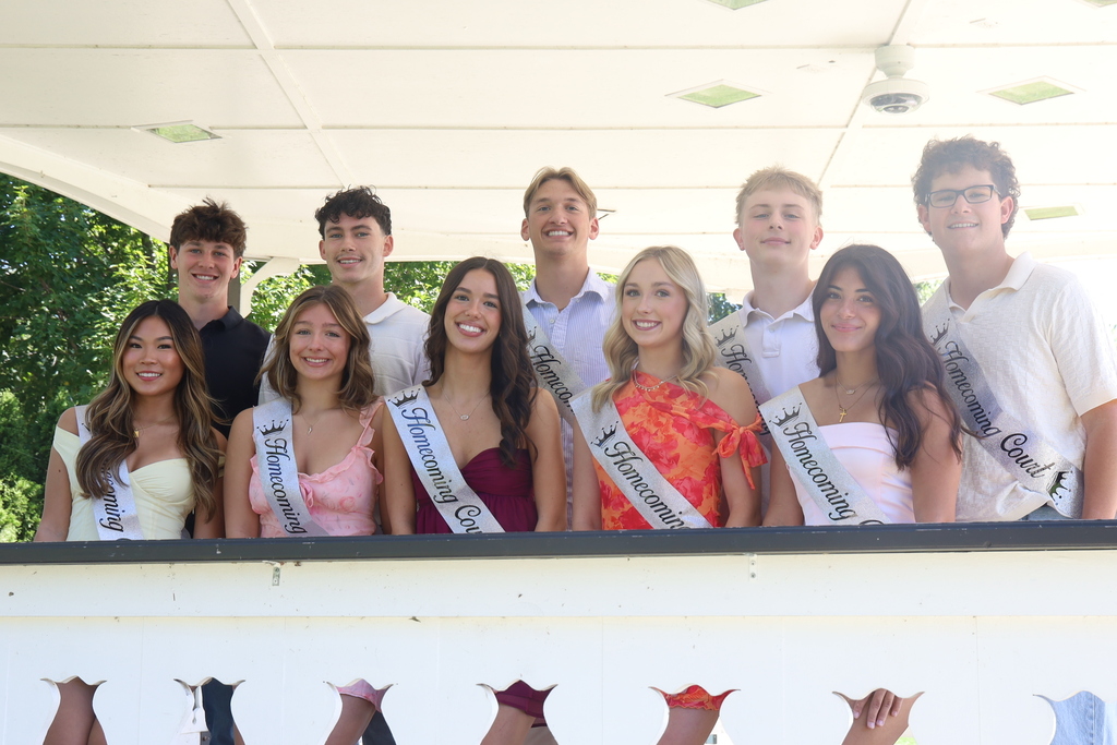 Homecoming court with sashes posing in gazeebo