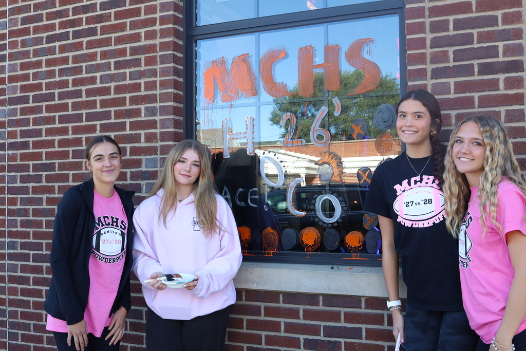 Students in front of window that says mchs '26 Hoco