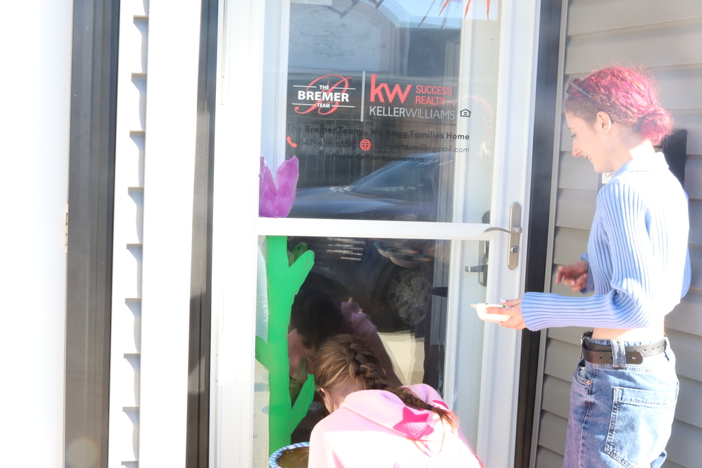 Student painting flower on door
