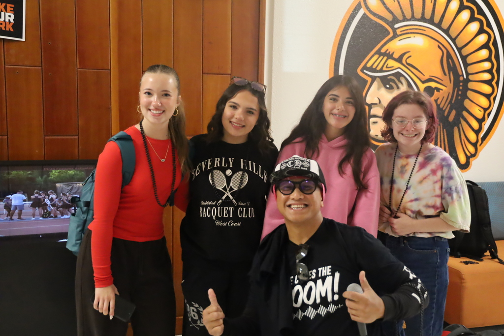 DJ posing with four students
