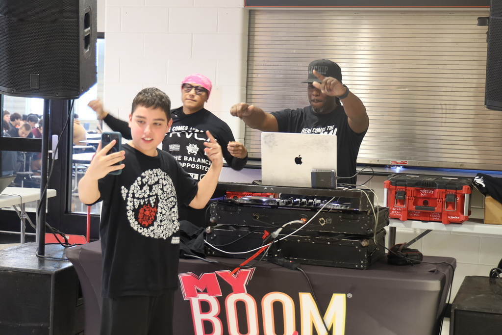 Student posing with DJs and his phone