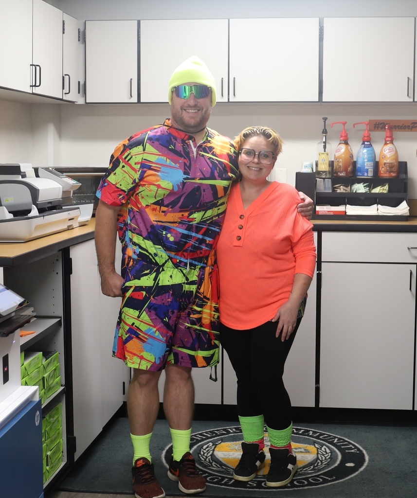 Staff one wearing 80s neon gear, the other wearing neon shirt