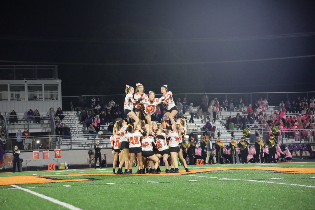 Cheer doing stunt on field with jerseys