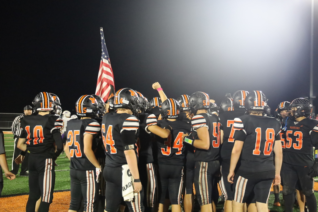 Football boys with American flag, one hlding out his arm with a pink bracelet