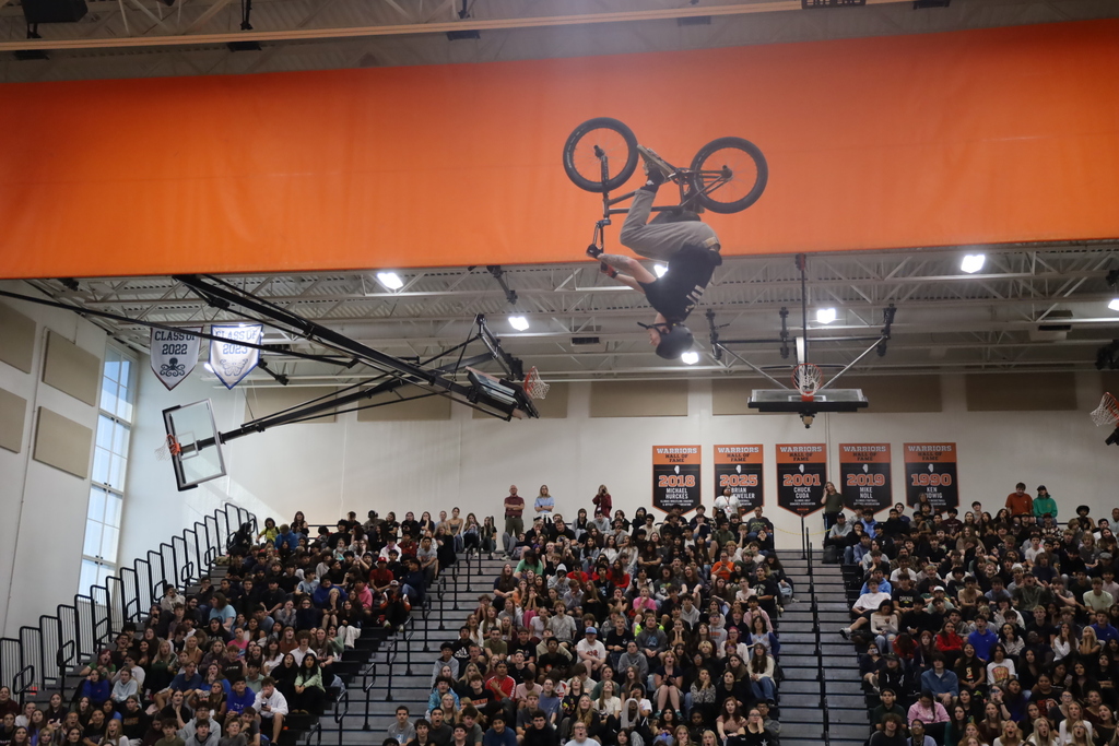 Matt upside down in the air on his bike over the gym