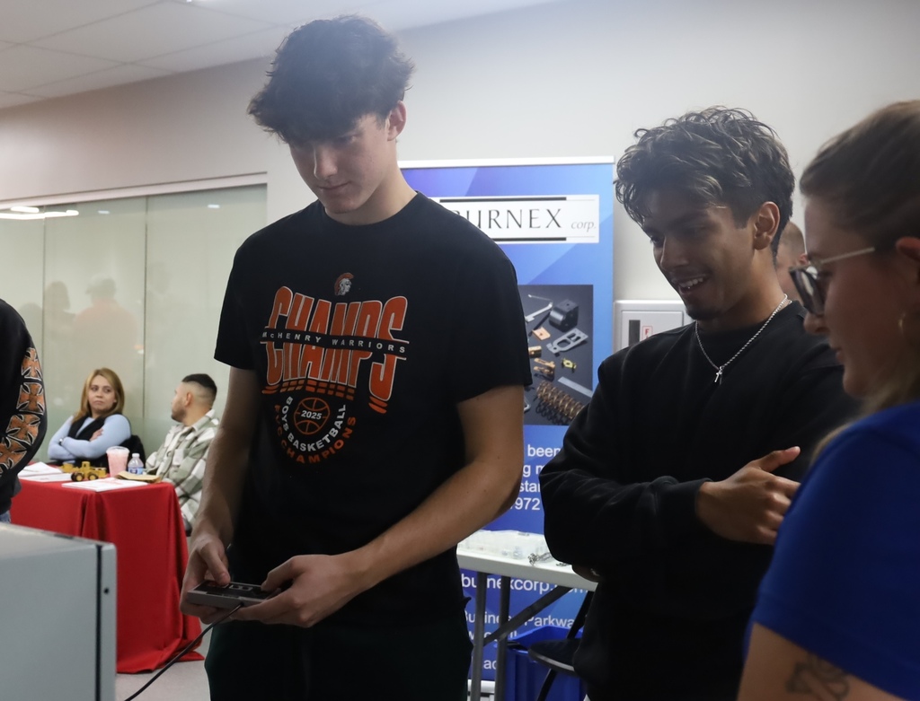 A student using remote control, the other one next to him smiling 