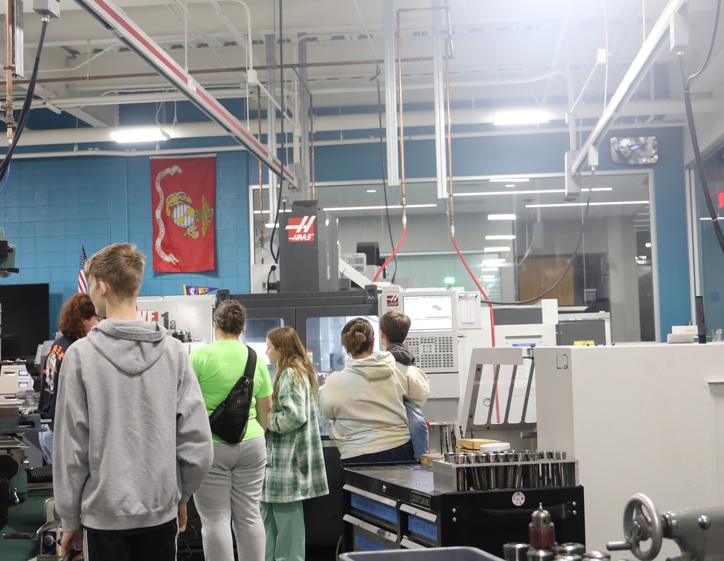 People in the manufacturing lab looking at a HAAS machine