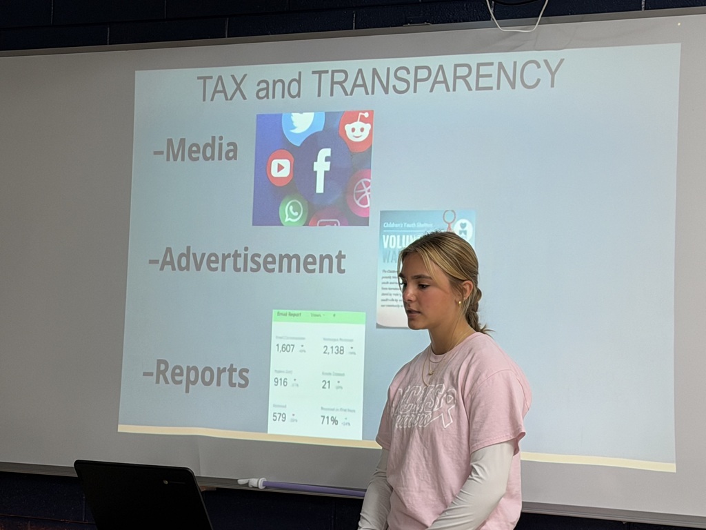 Student in front of slide that says tax and transparency media advertisement reports