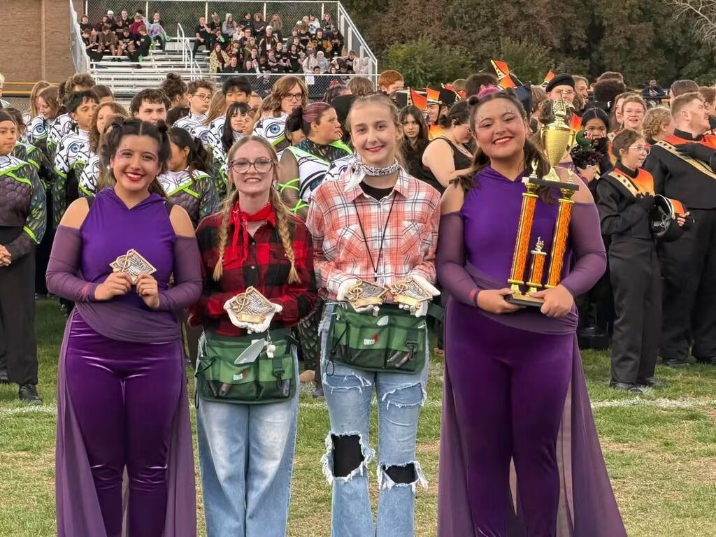 Four students holding trophies