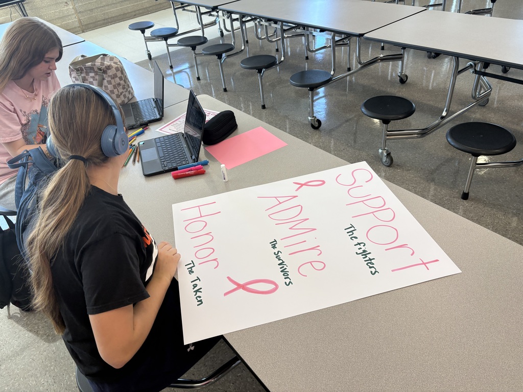 Student with poster that says Support the fighters. Admire the survivors. Honor the taken