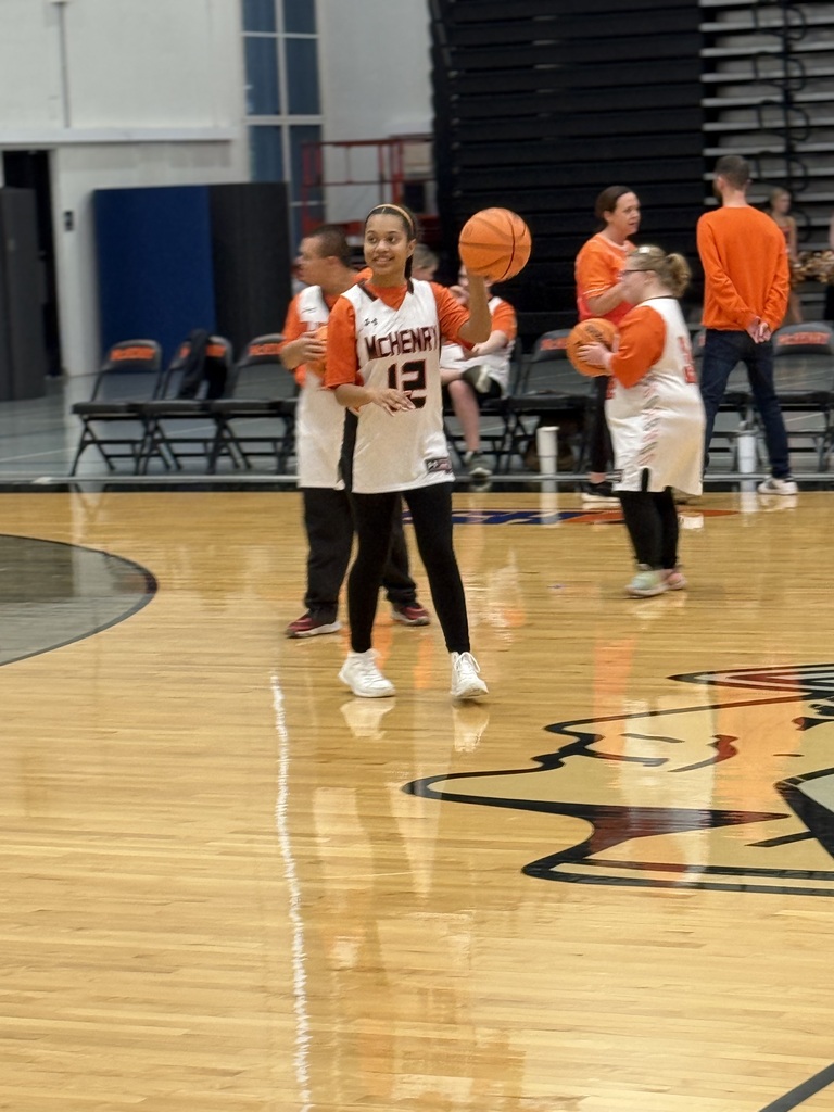 Student on the court holding basketball and smiling 
