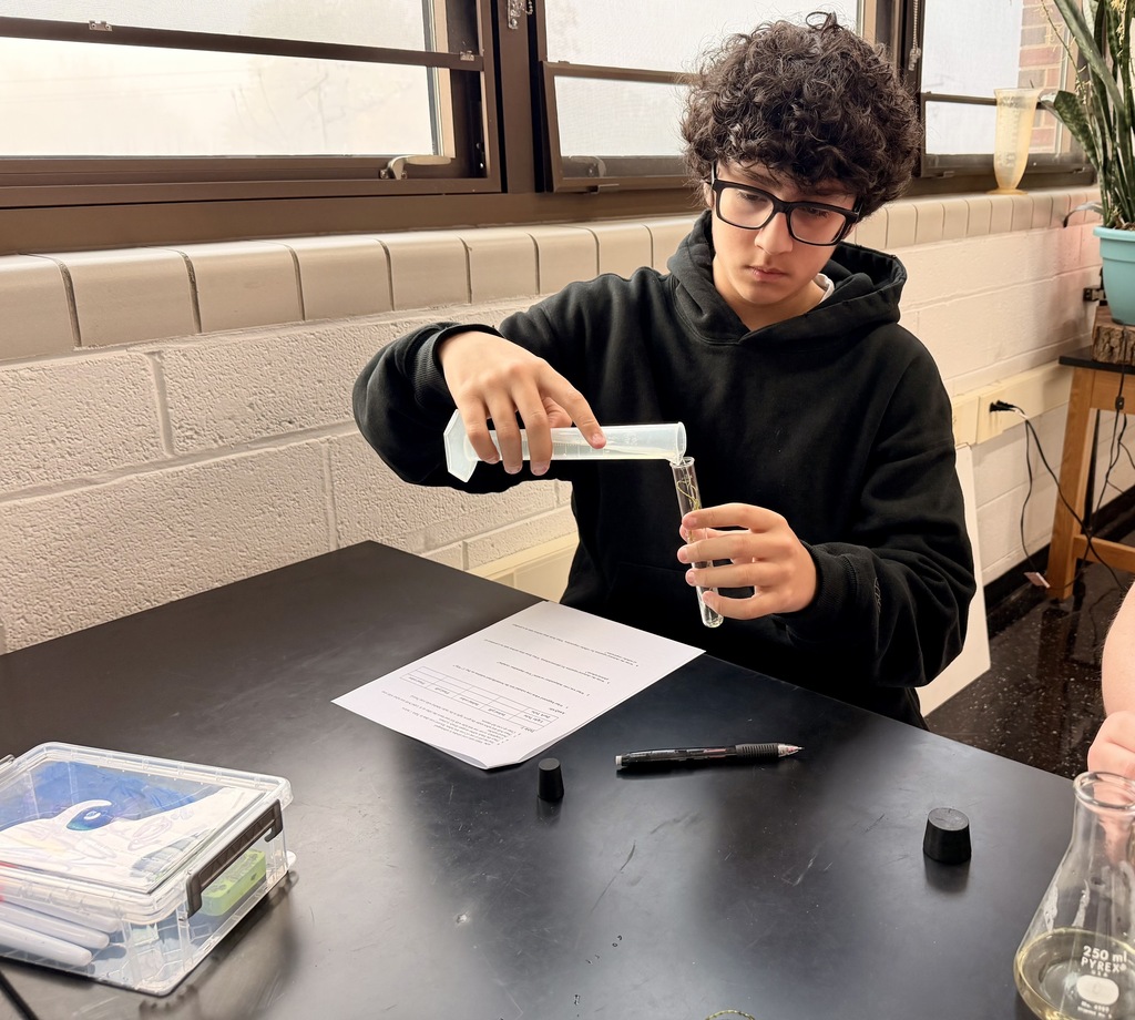 Student pouring solution into beaker