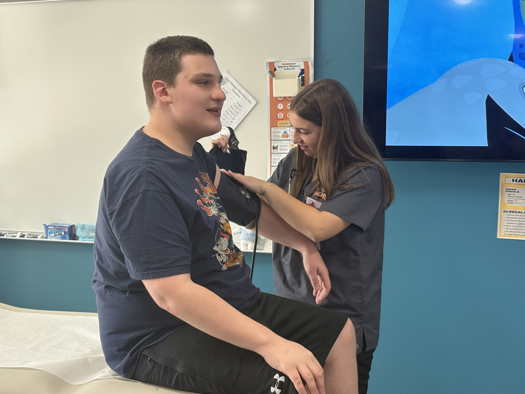 Student taking blood pressure of another student
