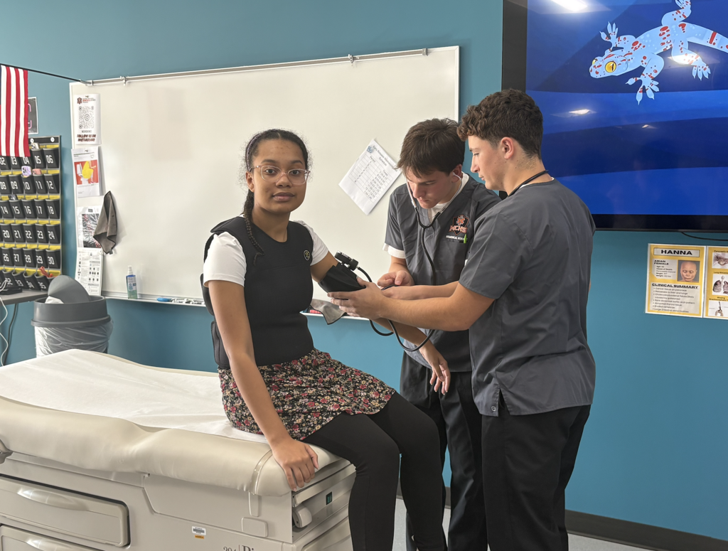 Students taking blood pressure of another student