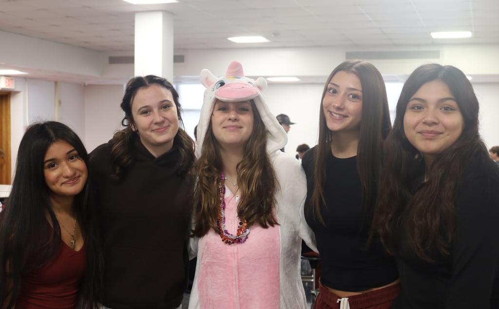 Five students posing. One in the middle with animal onesie.