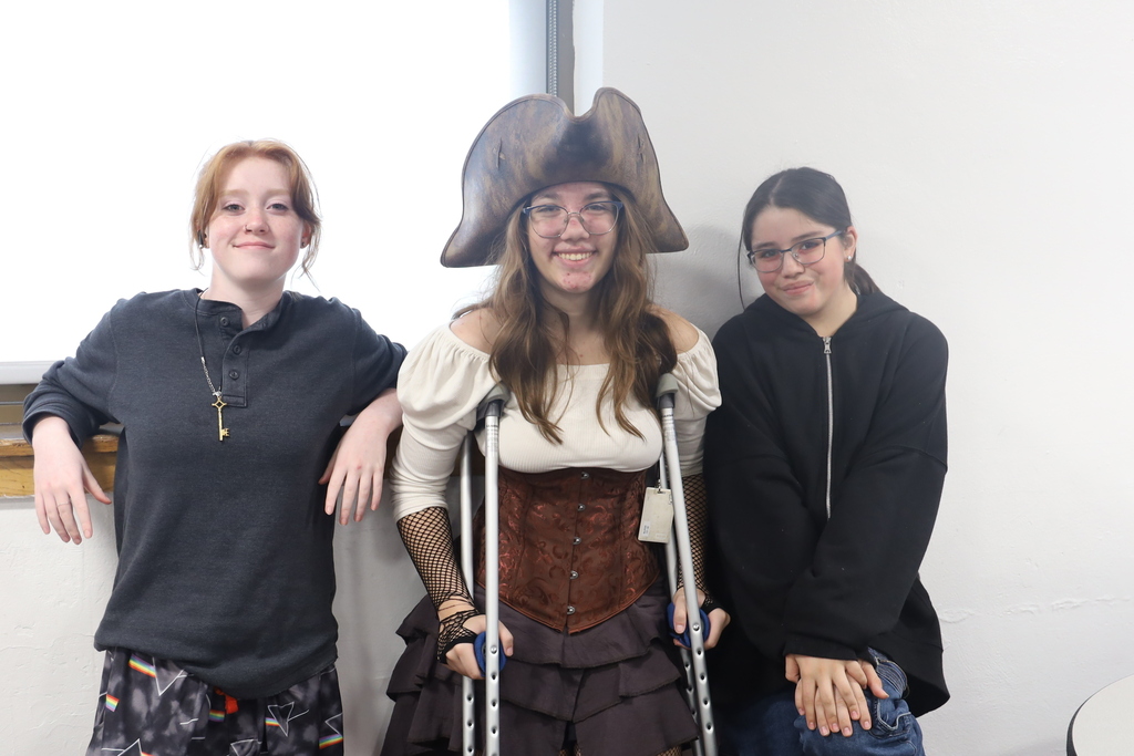 Two students posing next to a student in a middle that's a pirate
