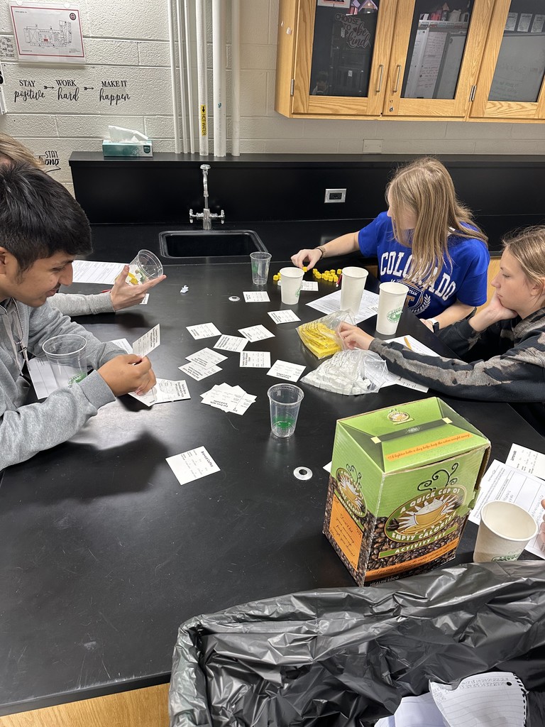 Students looking at cups and measurements in a health class