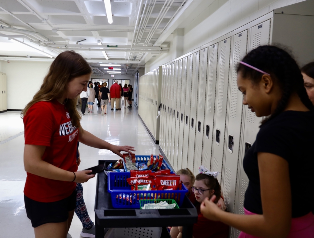 Student grabbing a snack from the treat trolley. Other student behind the treat trolley.