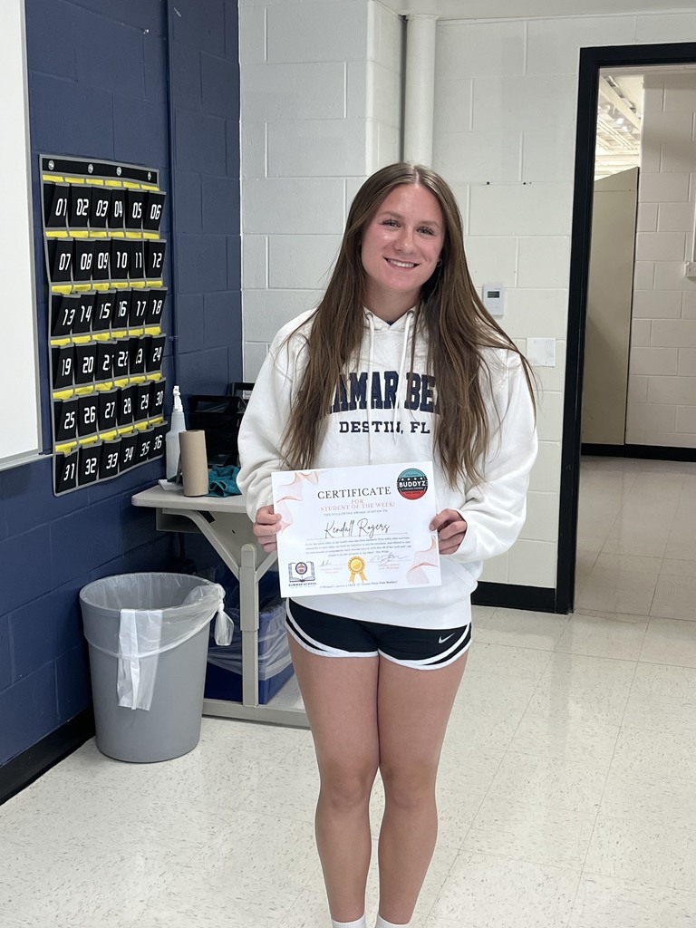 Student holding Student of the Week certificate